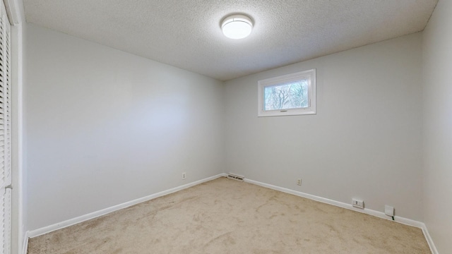 carpeted spare room with a textured ceiling