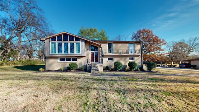 raised ranch with a front yard and a balcony