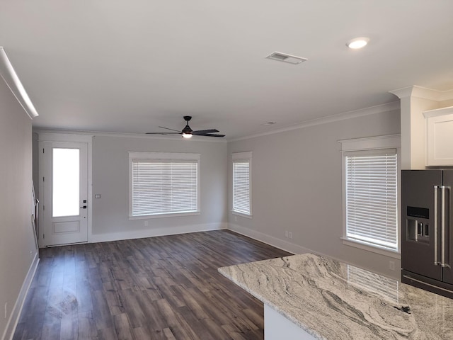 kitchen featuring high end fridge, white cabinets, and ornamental molding