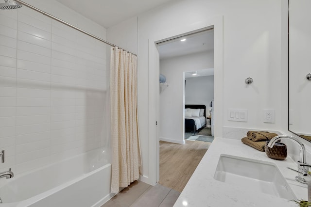 bathroom with hardwood / wood-style floors, vanity, and shower / bathtub combination with curtain