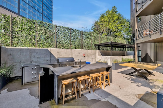 view of patio / terrace with exterior kitchen, a grill, and a wet bar