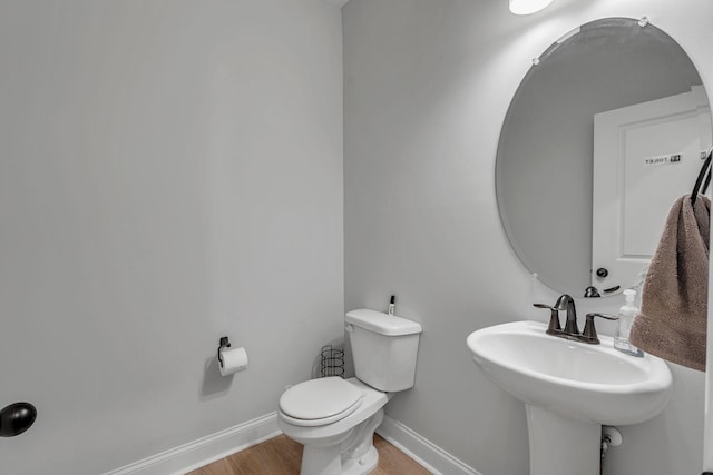 bathroom with hardwood / wood-style flooring, sink, and toilet