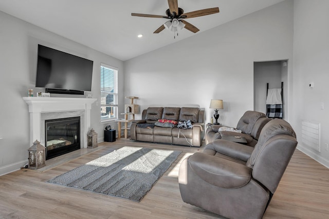 living room featuring light wood-type flooring, ceiling fan, and lofted ceiling