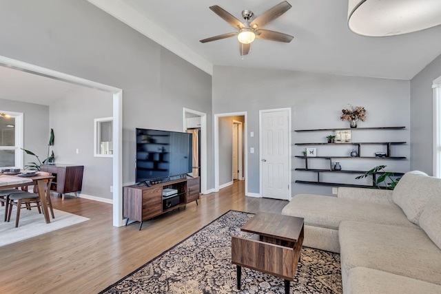 living room featuring ceiling fan, high vaulted ceiling, and wood-type flooring