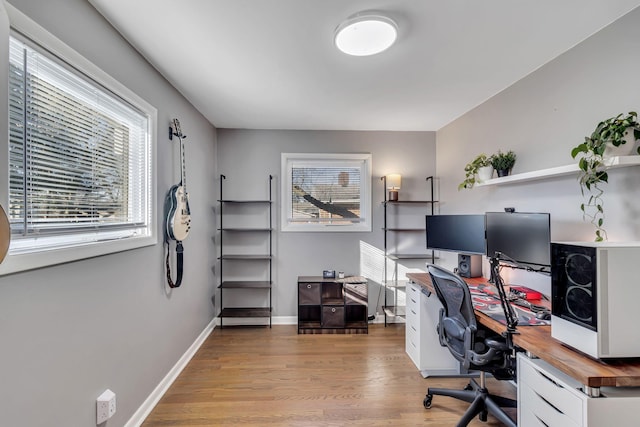 home office with light hardwood / wood-style flooring