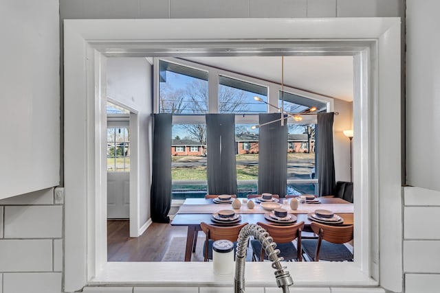 dining area featuring lofted ceiling, an inviting chandelier, and hardwood / wood-style flooring