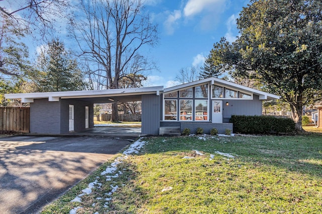 ranch-style home with a front yard and a carport