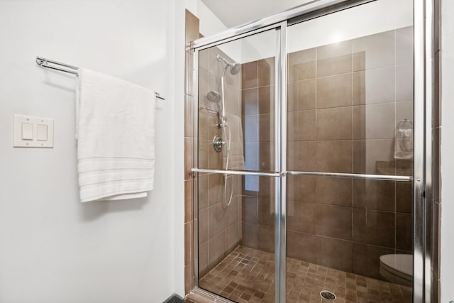 bathroom with toilet and a shower with shower door