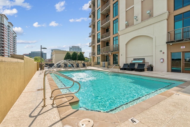 view of swimming pool with pool water feature and a patio area