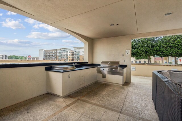 view of patio featuring grilling area, sink, and a balcony