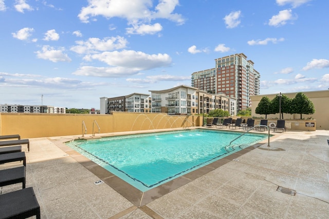 view of swimming pool with pool water feature and a patio