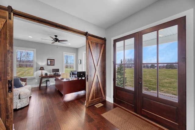 entryway featuring french doors, dark hardwood / wood-style flooring, a barn door, and ceiling fan