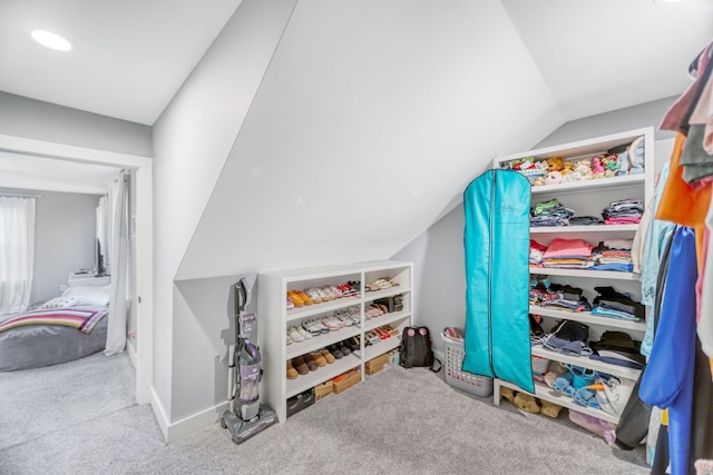 spacious closet featuring light colored carpet and lofted ceiling