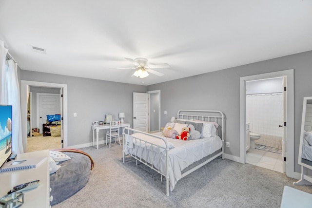 carpeted bedroom with ensuite bathroom and ceiling fan