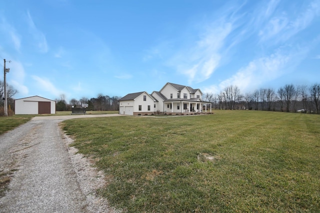 view of front of house with a front yard, an outbuilding, and a garage