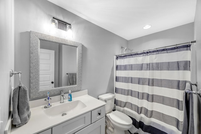 bathroom featuring a shower with shower curtain, vanity, and toilet