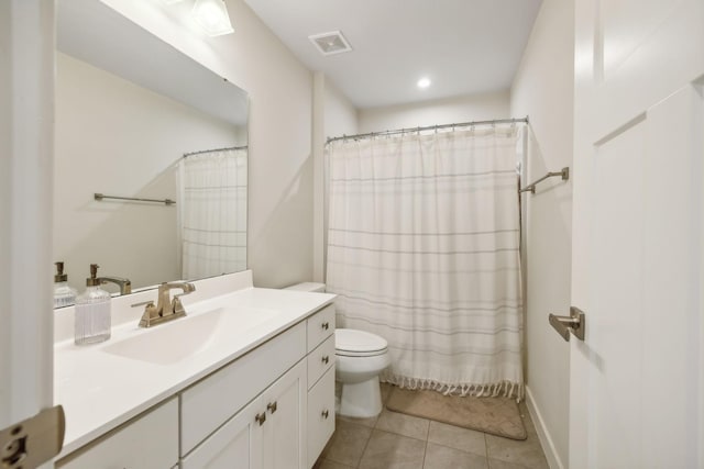 bathroom featuring tile patterned flooring, vanity, toilet, and walk in shower