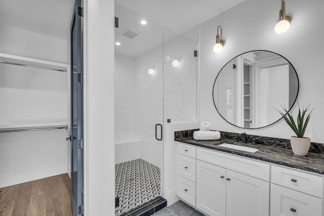 bathroom with vanity, hardwood / wood-style flooring, and a shower with door