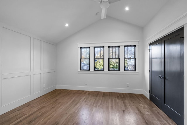 unfurnished bedroom featuring hardwood / wood-style floors, lofted ceiling with beams, ceiling fan, and a closet