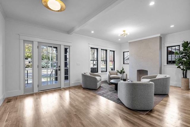 living room with beam ceiling, wood-type flooring, and crown molding