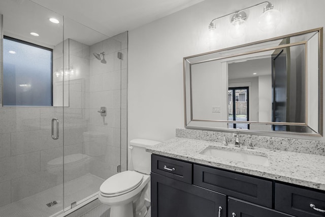 bathroom featuring toilet, vanity, and walk in shower