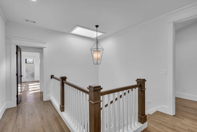 hallway with crown molding and light hardwood / wood-style flooring