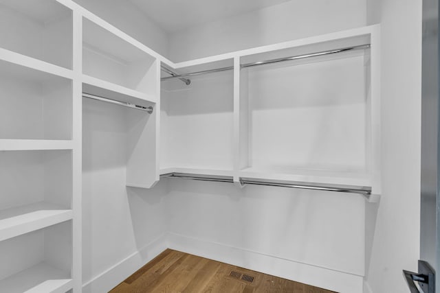 spacious closet with dark hardwood / wood-style flooring