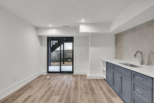 interior space featuring gray cabinetry, light wood-type flooring, and sink