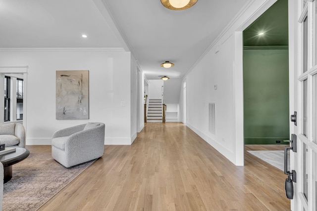 hallway featuring crown molding and light hardwood / wood-style floors