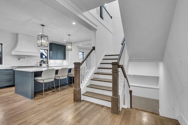 staircase with a chandelier and hardwood / wood-style flooring