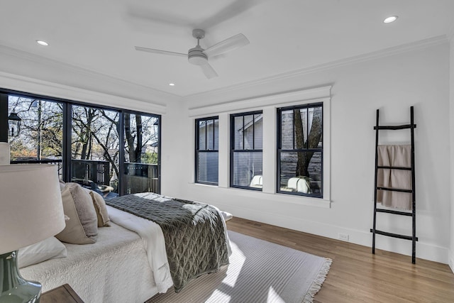 bedroom featuring hardwood / wood-style floors, ceiling fan, and crown molding