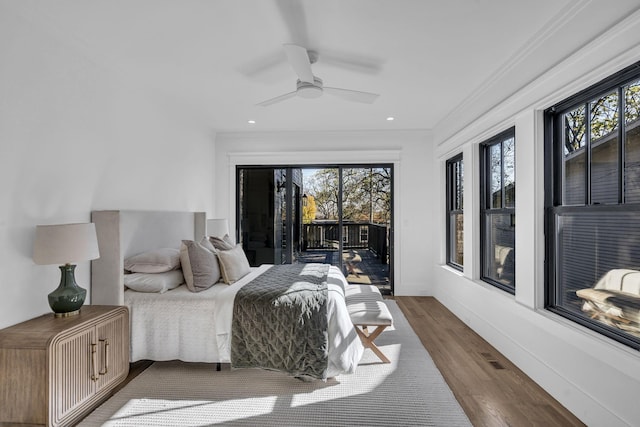 bedroom featuring access to outside, multiple windows, ceiling fan, and wood-type flooring