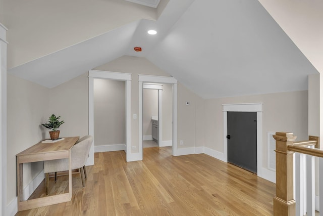 additional living space with light hardwood / wood-style floors and vaulted ceiling