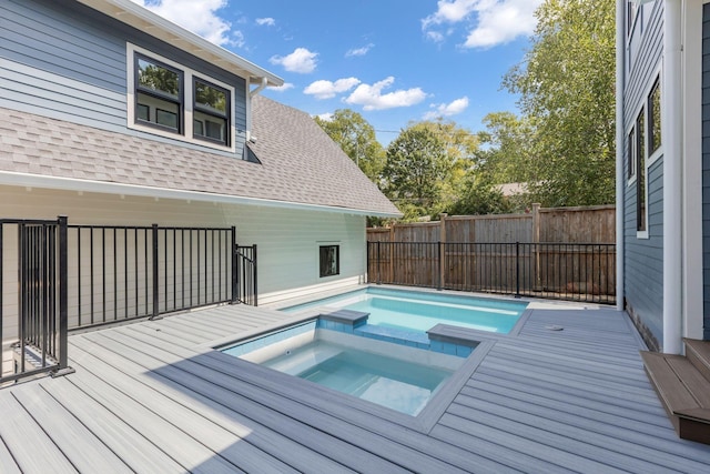 view of swimming pool featuring a deck and an in ground hot tub