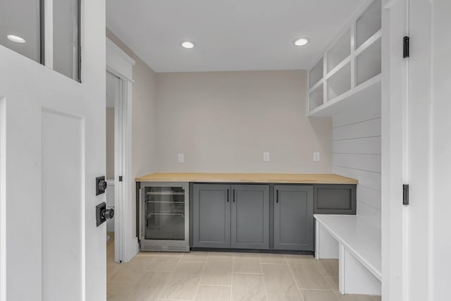 kitchen featuring gray cabinets, beverage cooler, and butcher block counters