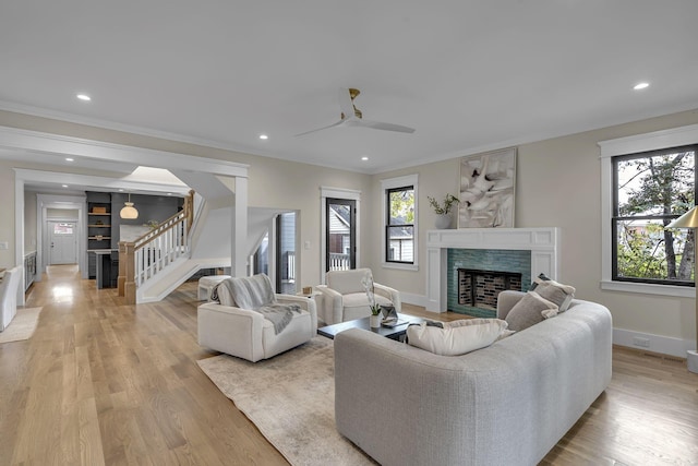 living room featuring light hardwood / wood-style flooring, a wealth of natural light, ornamental molding, and ceiling fan