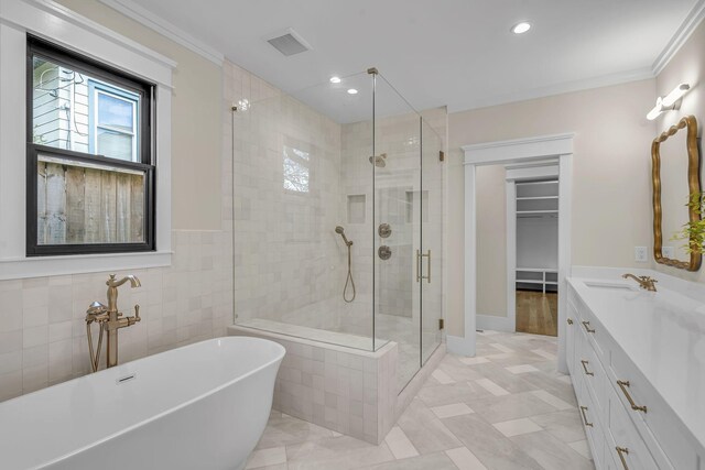 bathroom with plus walk in shower, vanity, and ornamental molding