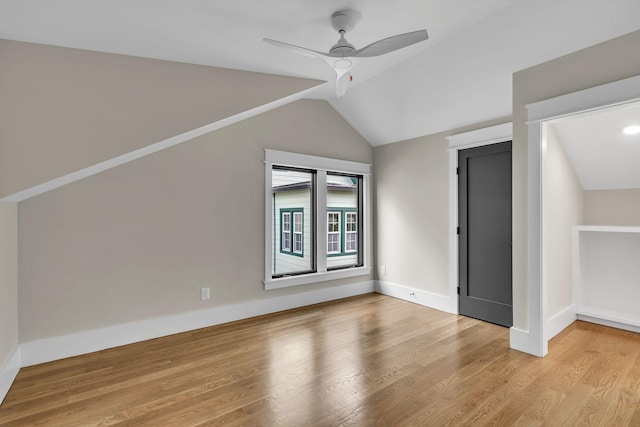 additional living space featuring light hardwood / wood-style floors, vaulted ceiling, and ceiling fan