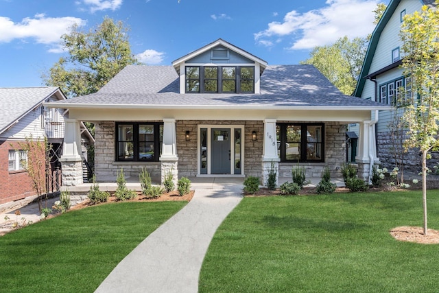 view of front of property featuring covered porch and a front lawn