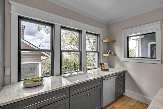 kitchen featuring gray cabinetry, light stone countertops, sink, stainless steel dishwasher, and light hardwood / wood-style floors