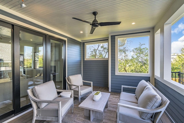 sunroom with ceiling fan and wooden ceiling