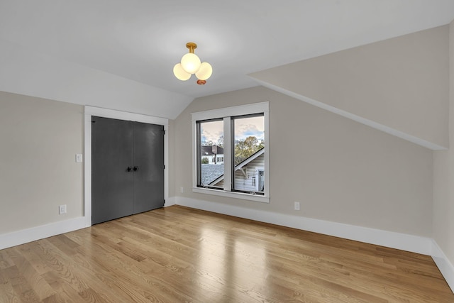 bonus room featuring light wood-type flooring and lofted ceiling