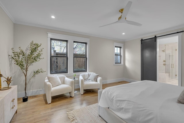 bedroom featuring crown molding, ceiling fan, a barn door, connected bathroom, and light hardwood / wood-style floors