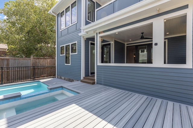 wooden terrace with a swimming pool with hot tub and ceiling fan