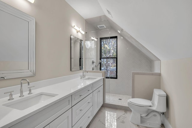 bathroom featuring a tile shower, vanity, lofted ceiling, and toilet