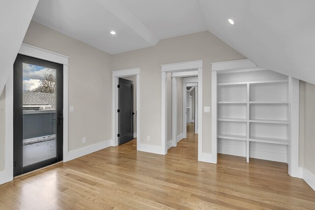 bonus room with built in shelves and light hardwood / wood-style floors