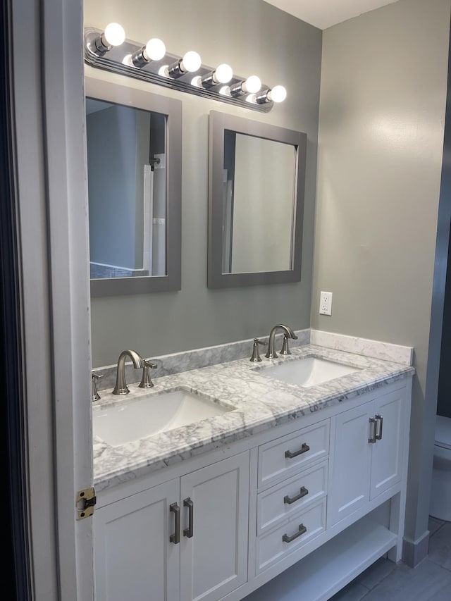 bathroom featuring vanity, tile patterned flooring, and toilet