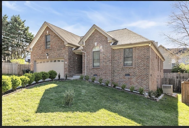 view of property featuring a garage and a front lawn