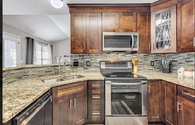 kitchen featuring light stone countertops, appliances with stainless steel finishes, sink, and backsplash