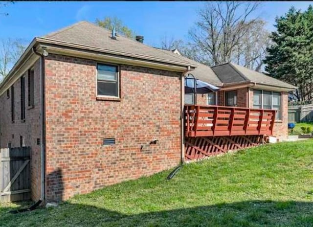 view of property exterior with a wooden deck and a lawn